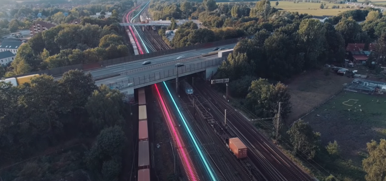 Straßenüberführung führt über mehrgleisige Bahnstrecke, auf der Züge fahren. Straßenüberführung führt über mehrgleisige Bahnstrecke, auf der Züge fahren.