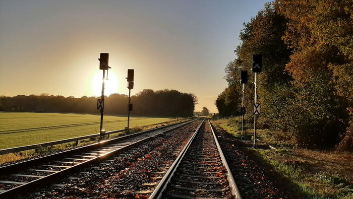 Bahnstrecke im Sonnenaufgang mit den neuen Signalen.
